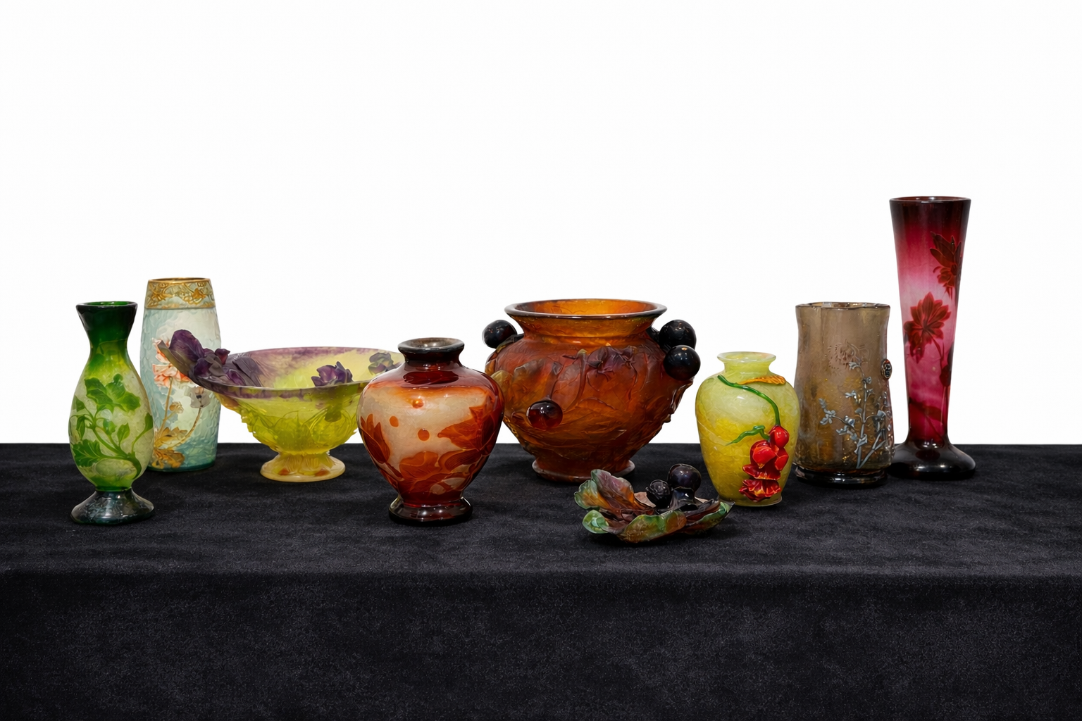 Mehrere farbige Jugendstil Kunstglas Vasen und Schalen auf weißem Sockel vor neutralem Hintergrund – Cameoglas und dekorative Glasobjekte im Stil von Gallé, Daum Nancy, Lötz Wien und Lalique